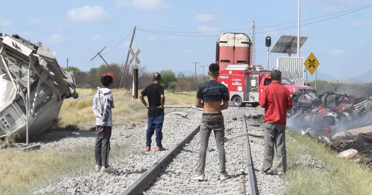 Migrantes ayudaron a salir sano y salvo de la cabina en llamas a trailero, quien impactó su unidad contra un ferrocarril.